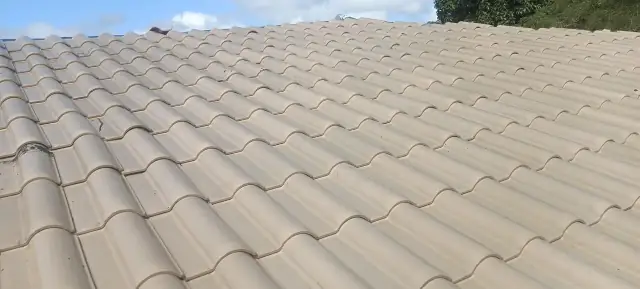 Telhas novas em bege claro, de perfil curvo, na cobertura reformada